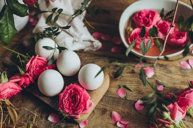 Em uma mesa de madeira são preparados ovos para colorir para a Páscoa em rosa