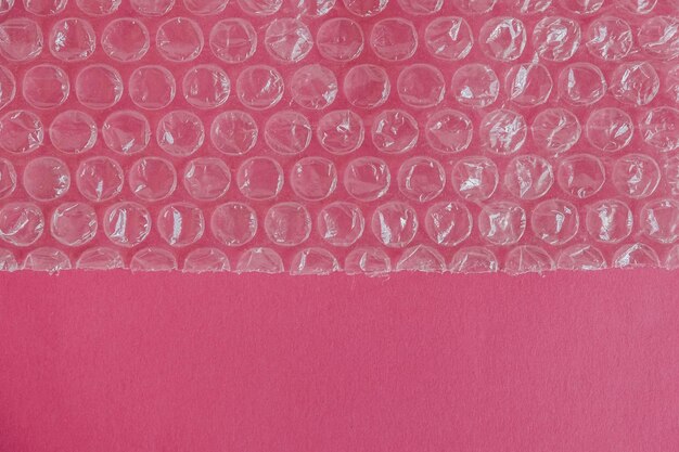 Embalagem com bolhas de ar em um fundo rosa. textura de plástico bolha, embalagem, filme bolha de ar. vista do topo. copie, espaço vazio para texto