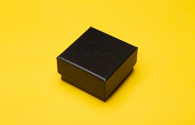Embalagem de produto mini caixa preta isolada na parede amarela