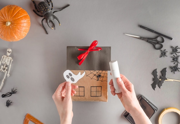 Embalagem passo a passo de um presente para o Halloween, plana. cola o papel fantasma