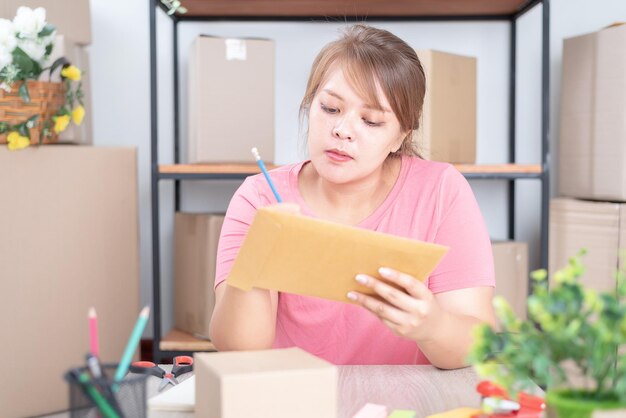 Embalaje de productos para la entrega. Mujer sosteniendo en la mano una pequeña caja de papel. Embalaje de productos para la entrega