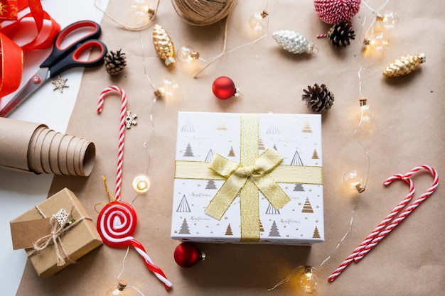 Embale um presente para o Natal e o ano novo em cones de papel kraft, tesoura, fita, etiquetas, com simulação de decoração natural feita à mão, faça você mesmo, clima festivo, fundo flatlay