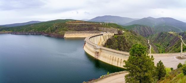 Embalse panorámico entre las montañas verdes con presa de pantano que contiene el agua Atazar Madrid