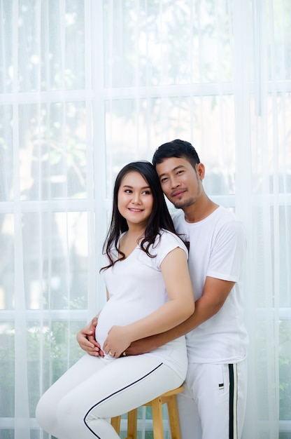 La embarazada está feliz con su marido, preparándose para mirar al niño que está a punto de dar a luz.