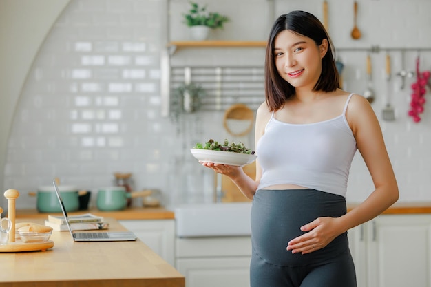 embarazo alimentos saludables y personas concepto de primer plano de una mujer embarazada feliz comiendo ensalada de verduras para el desayuno en la cama en casa concepto de cuidado prenatal de niño y maternidad