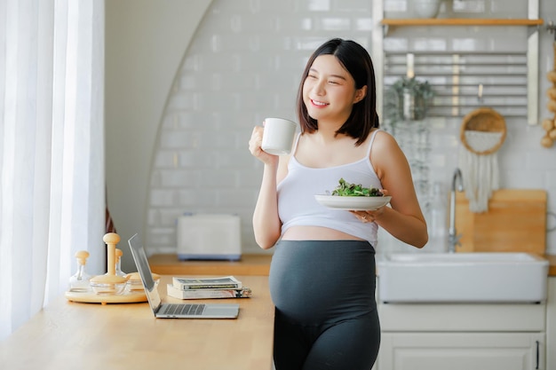 Foto embarazo alimentos saludables y personas concepto de primer plano de una mujer embarazada feliz comiendo ensalada de verduras para el desayuno en la cama en casa concepto de cuidado prenatal de niño y maternidad