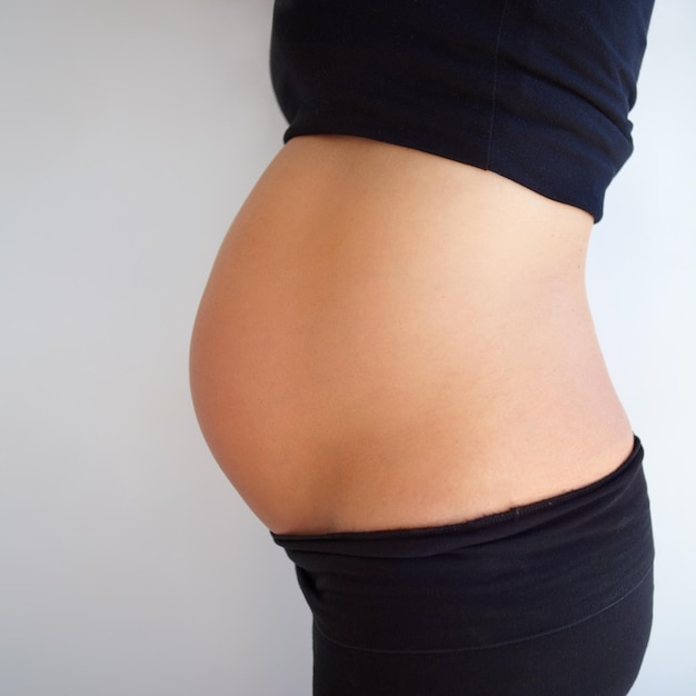 Foto el embarazo es hermoso captura recortada de una vista de ángulo lateral del estómago de la mujer embarazada