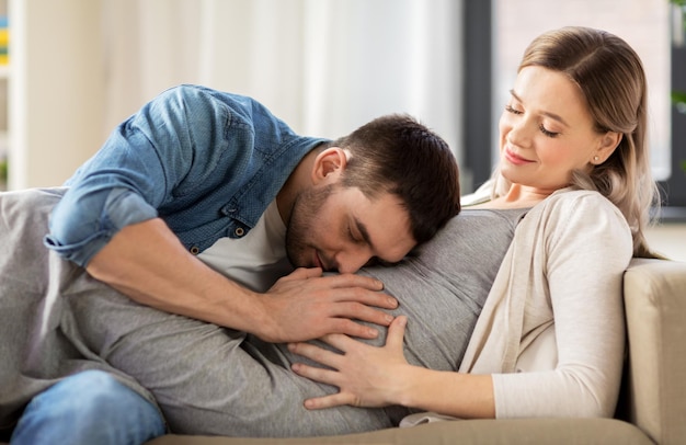 embarazo y la gente concepto hombre feliz con mujer embarazada en casa