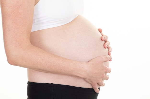 Embarazo hermoso perfil vientre barriga de mujer embarazada sobre fondo blanco.