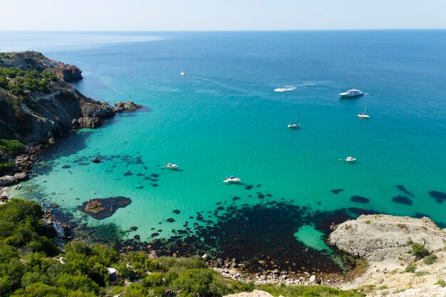 Embarcaciones de recreo en una hermosa laguna marina. Vista desde lo alto del acantilado. Agua de mar verde esmeralda azul en un día soleado. foto de alta calidad