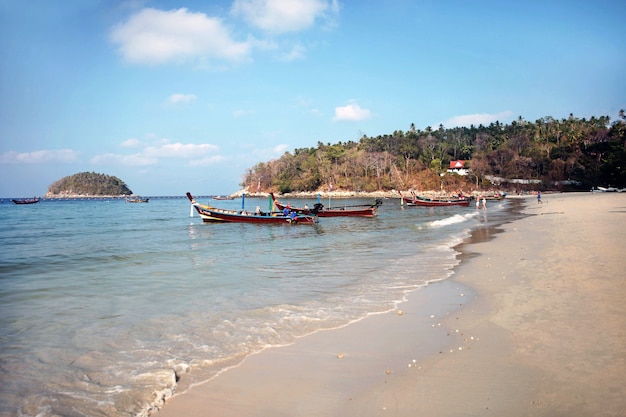 Embarcaciones tradicionales de cola larga en la playa con el telón de fondo de las islas del Mar de Andaman.