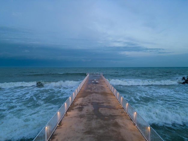 Embarcadero iluminado con un cielo espectacular sobre el tormentoso mar oscuro al atardecer Varna Bulgaria