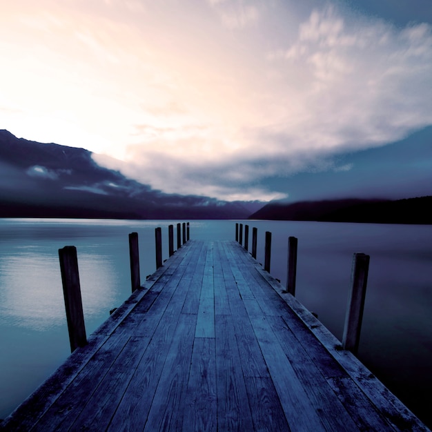 Embarcadero y un lago tranquilo al amanecer, Nueva Zelanda.