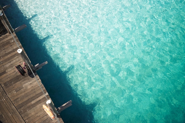 Embarcadero de madera con aguas cristalinas y turquesas del mar tropical Vista superior aérea Isla Rawa Malasia