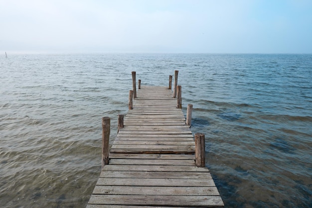 Embarcadero de madera en el lago en un estado de ánimo brumoso