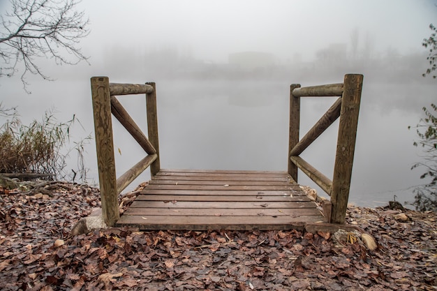 Embarcadero de madera en un lago con niebla