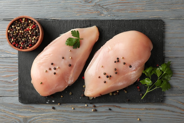 Embarque com carne de frango no espaço de madeira. Cozinhar frango