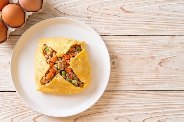 Embrulho de ovo ou ovo recheado com carne de porco picada, cenoura, tomate e ervilha