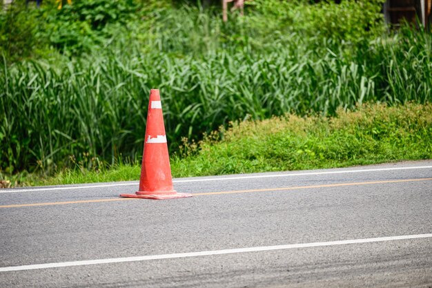 Embudo naranja de la señal de tráfico en la carretera de asfalto