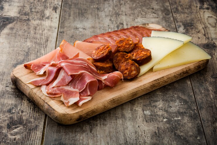 Foto embutidos españoles embutidos queso, chorizo y jamón sobre mesa de madera
