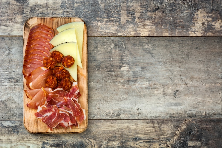 Foto embutidos españoles (embutidos) queso, salchichas y jamón en mesa de madera