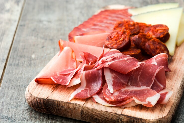 Foto embutidos españoles queso, chorizo y jamón en mesa de madera