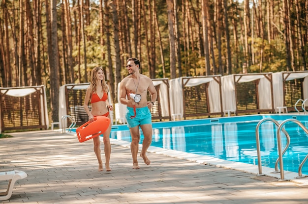 Emergencia. Dos socorristas de la piscina corriendo hacia el lugar de emergencia.