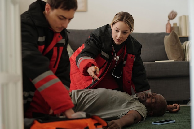 Emergency Responders Assisting Unconscious Man Indoors
