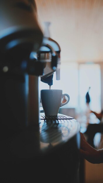 Foto emisión de café de la cafetera de espresso en la taza