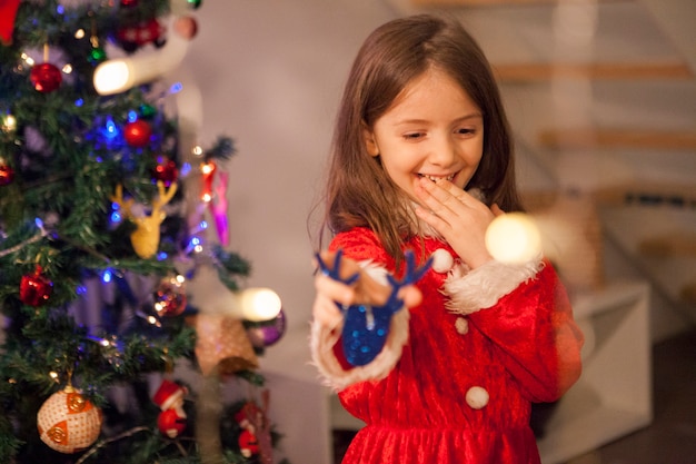 Emoción cerca de navidad de niño pequeño con traje de santa