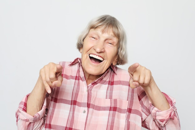 Emoción de estilo de vida y concepto de personas Abuela anciana con cara de asombro Retrato de abuela con camisa rosa