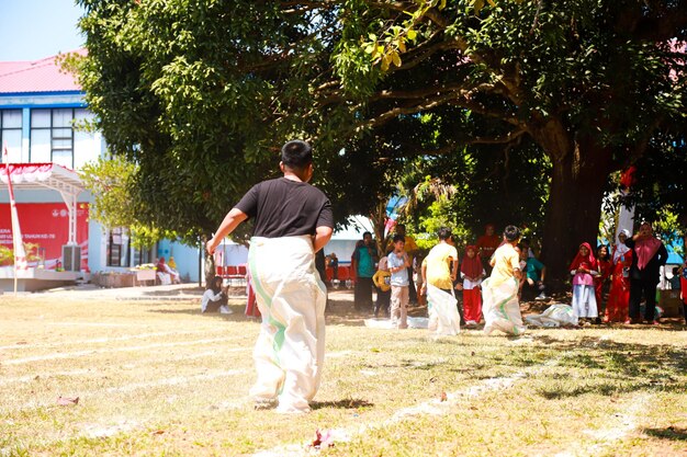 Foto la emoción que ocurre en los juegos de carreras de sacos de los niños en las competiciones tradicionales