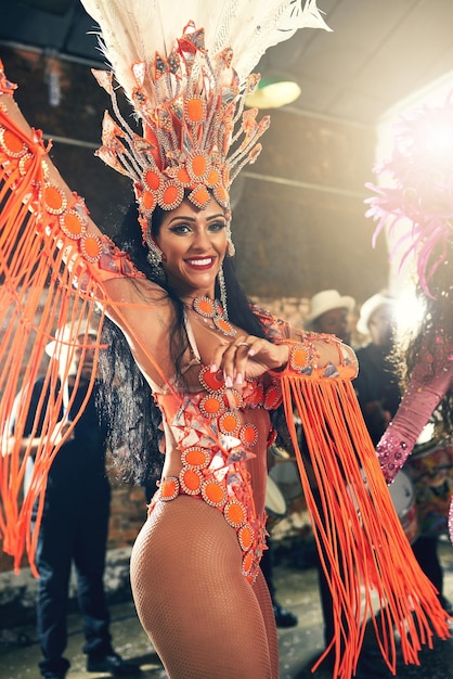 La emoción de tocar en vivo Retrato recortado de una hermosa bailarina de samba actuando en el Carnaval con su banda