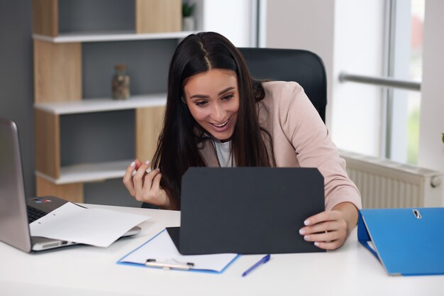 Emocionada empresaria satisfecha celebrando el éxito empresarial motivada por un gran resultado de trabajo financiero