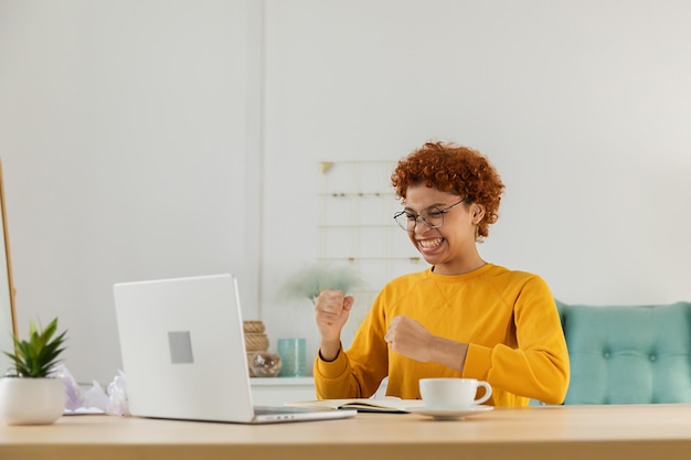 Emocionada feliz mujer afroamericana eufórica ganadora estudiante mirando la computadora portátil pasó el examen de lectura