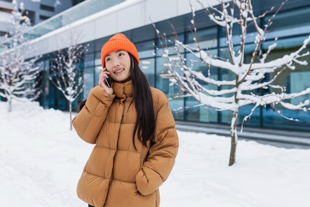 Emocionada y feliz mujer coreana hablando por teléfono móvil y riendo, escuchó buenas noticias. Retrato de hipster asiático alegre con smartphone