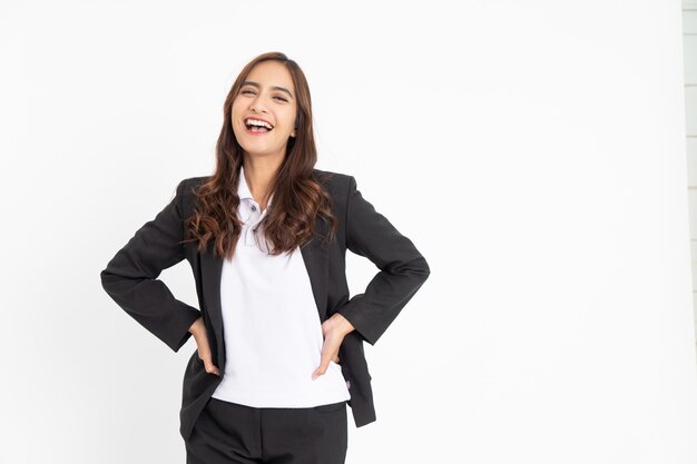 Emocionada joven empresaria asiática riendo felizmente con ambas manos en la cintura