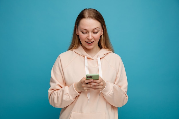 Emocionada joven rubia con su teléfono móvil