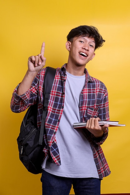 Emocionado estudiante asiático inteligente que lleva una mochila mostrando un gesto de idea