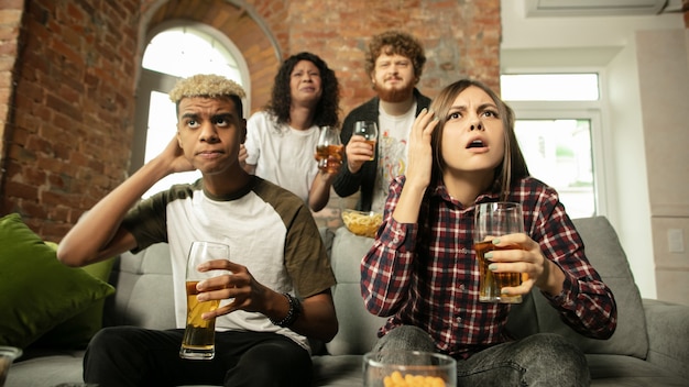 Emocionado grupo de personas viendo el campeonato de partidos deportivos en casa