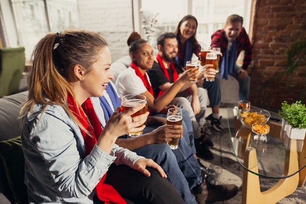 Emocionado grupo de personas viendo fútbol, partido deportivo en casa