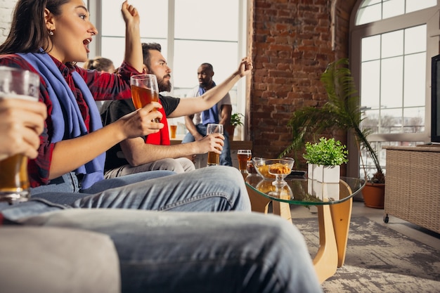 Emocionado grupo de personas viendo el partido de fútbol en casa