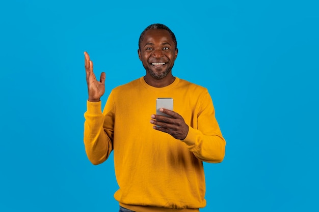 Emocionado hombre afroamericano con gestos de teléfono celular