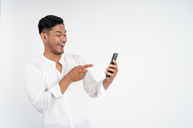 Emocionado joven asiático sorprendido al mirar la pantalla