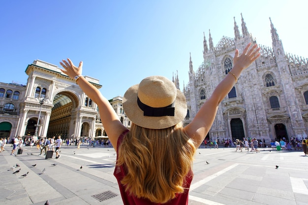 Emocionado joven con los brazos levantados en la Plaza de la Catedral de Milán Italia