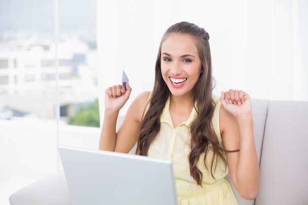 Foto emocionado joven morena con tarjeta de crédito