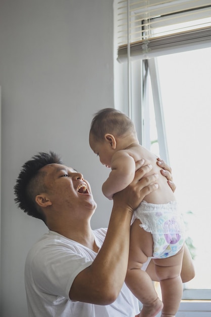 Emocionado padre levanta lindo bebé en casa