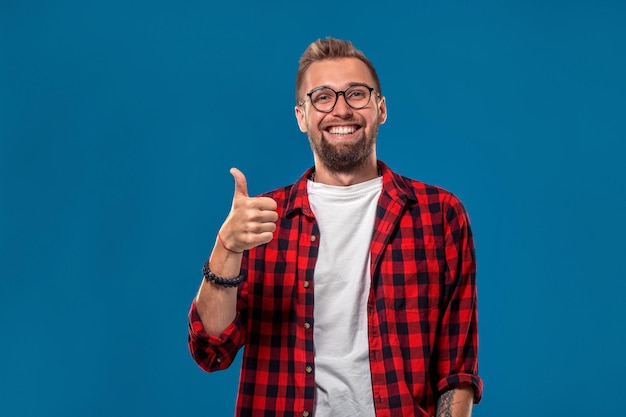 Emocional e as pessoas conceito jovem barbudo homem em estilo moderno de camisa quadriculada, o cara mostra seu ha ...