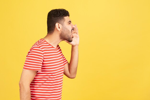 Emocional joven en camiseta roja sobre fondo amarillo