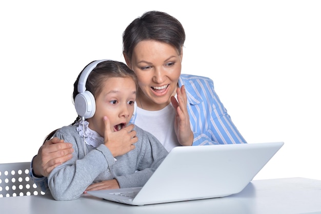 Foto emocional madre e hija usando laptop sobre fondo blanco.